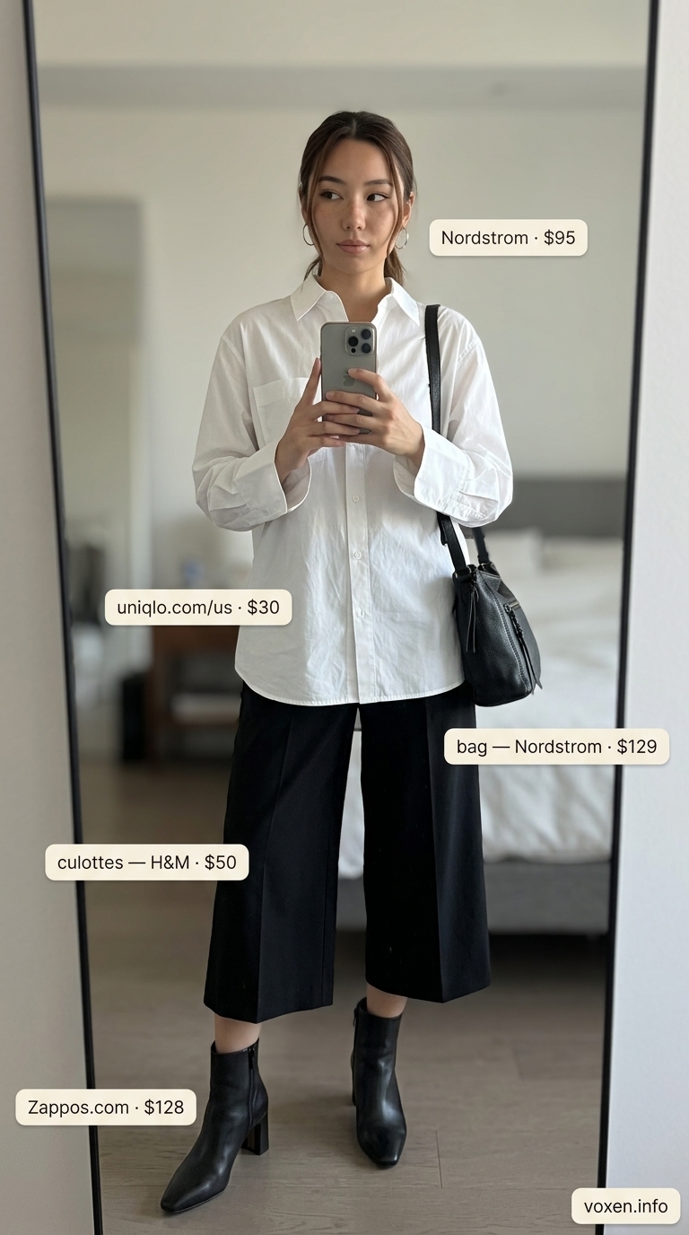 Black tailored culottes for women 2026, styled with an oversized white shirt and ankle boots for a modern business casual look.
