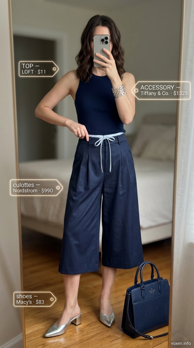 Navy tailored culottes with a navy ribbed tank, silver cuff, and metallic mules for modern office style 2026.