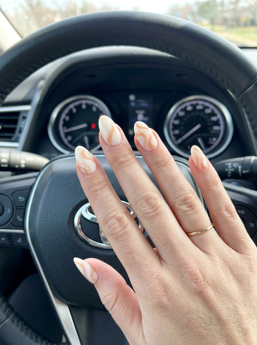 Pale peach almond nails with creamy white swirls, ideal for summer vacation and retro parties in 2026.