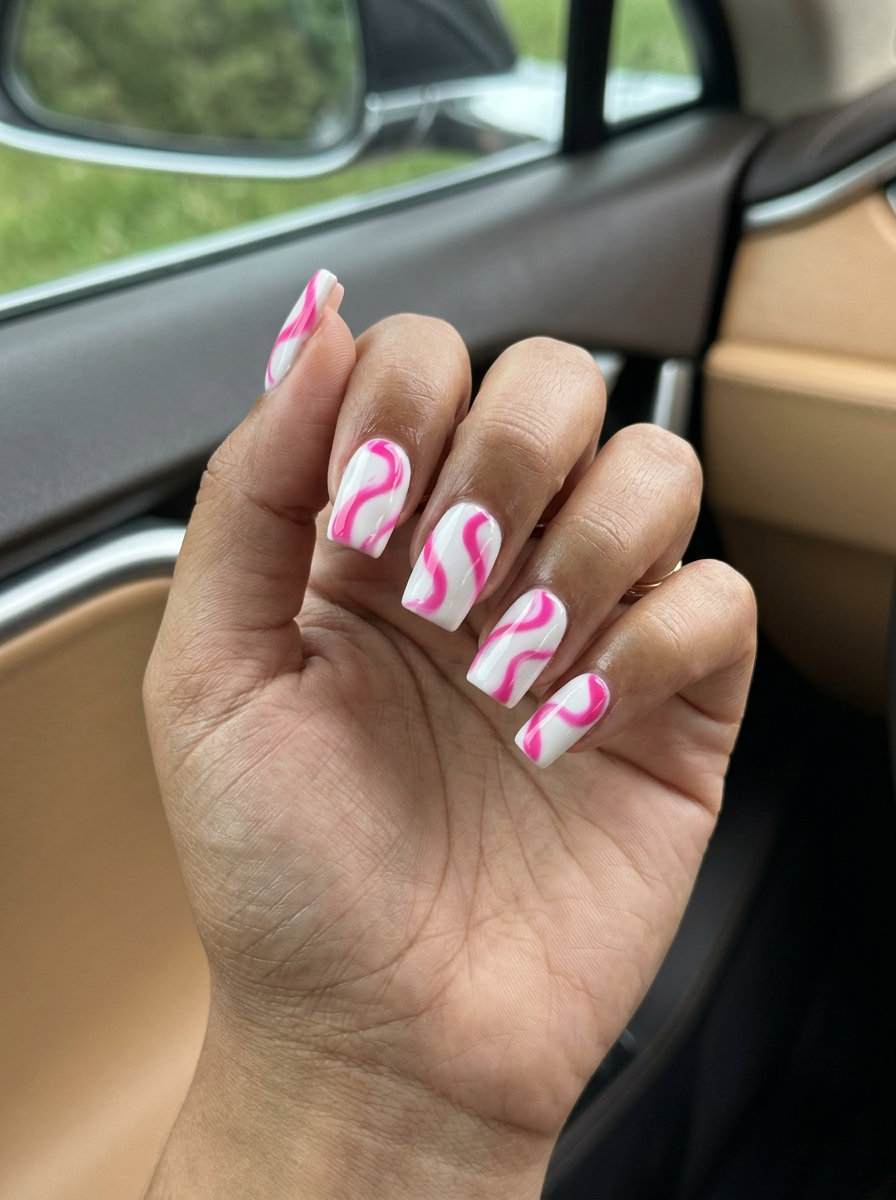 Energetic hot pink and white abstract swirl nails for festivals and night outs. Colourful summer nails 2026.