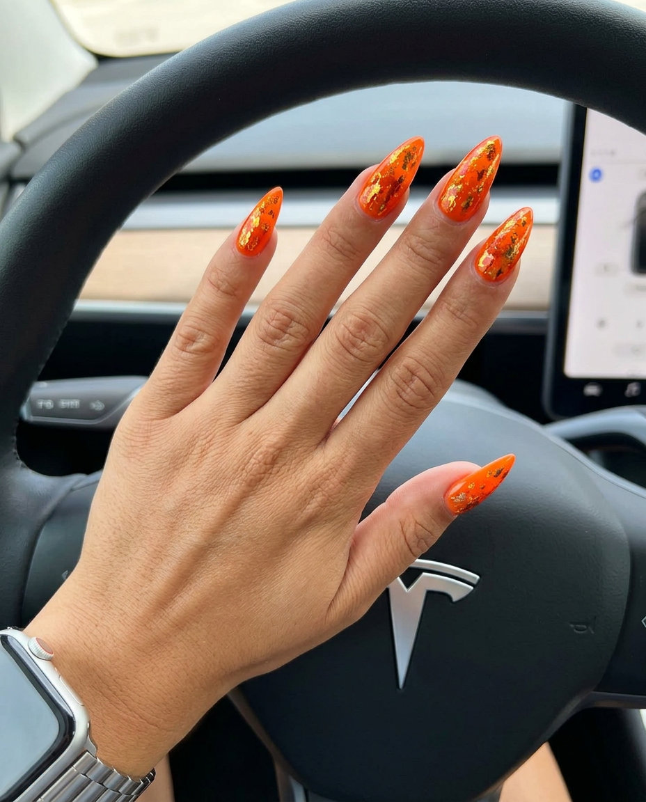 Neon Summer Nails 2026: Fiery Foil Flakes Neon summer nails 2026: Fiery Foil Flakes Stiletto in safety orange with gold and copper metallic accents.