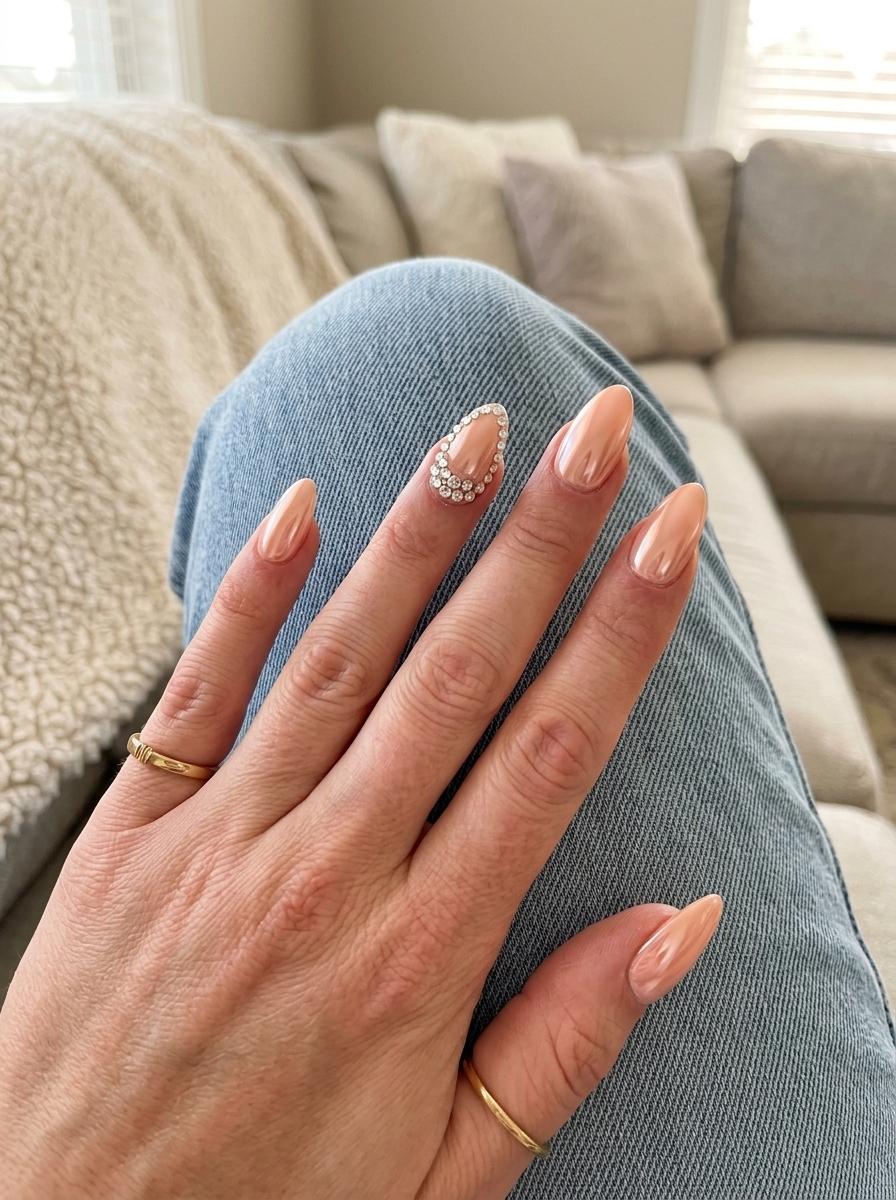 Peach chrome rhinestone accent nails for spring 2026 wedding guest outfits. Glamorous romantic.