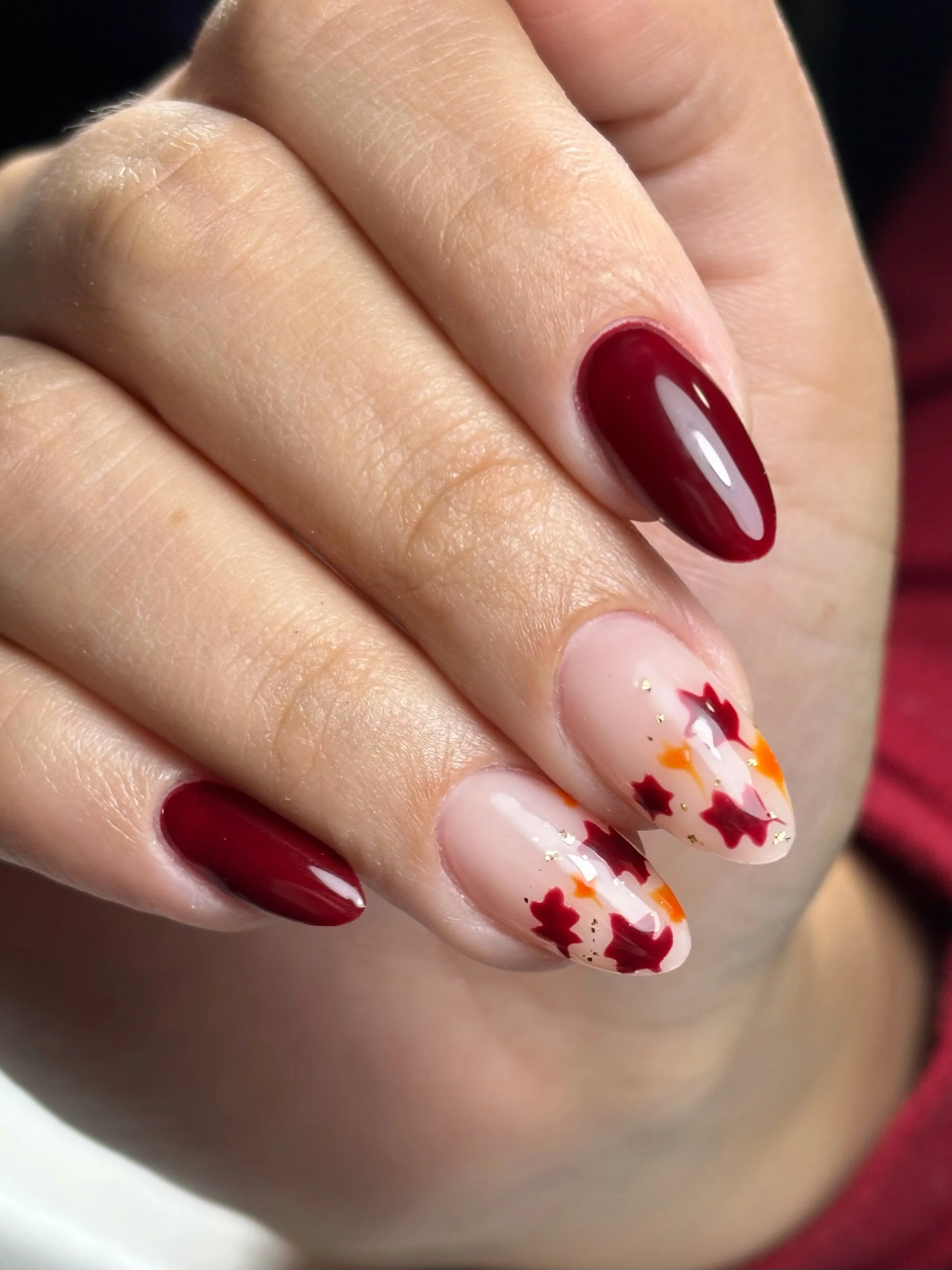 fall red nails 2026 Classic Burgundy Nails With Delicate Maple Leaf Accents