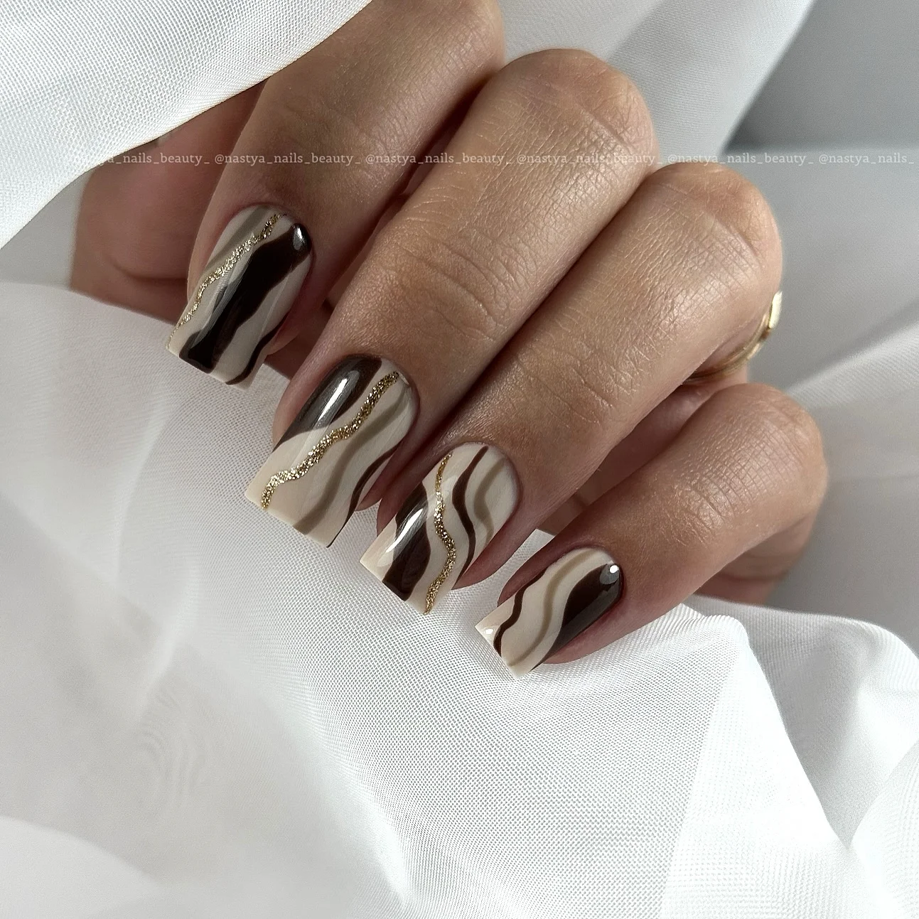 fall dark nail shadow ideas 2026 Chocolate Brown And Cream Waves With Gold Accents