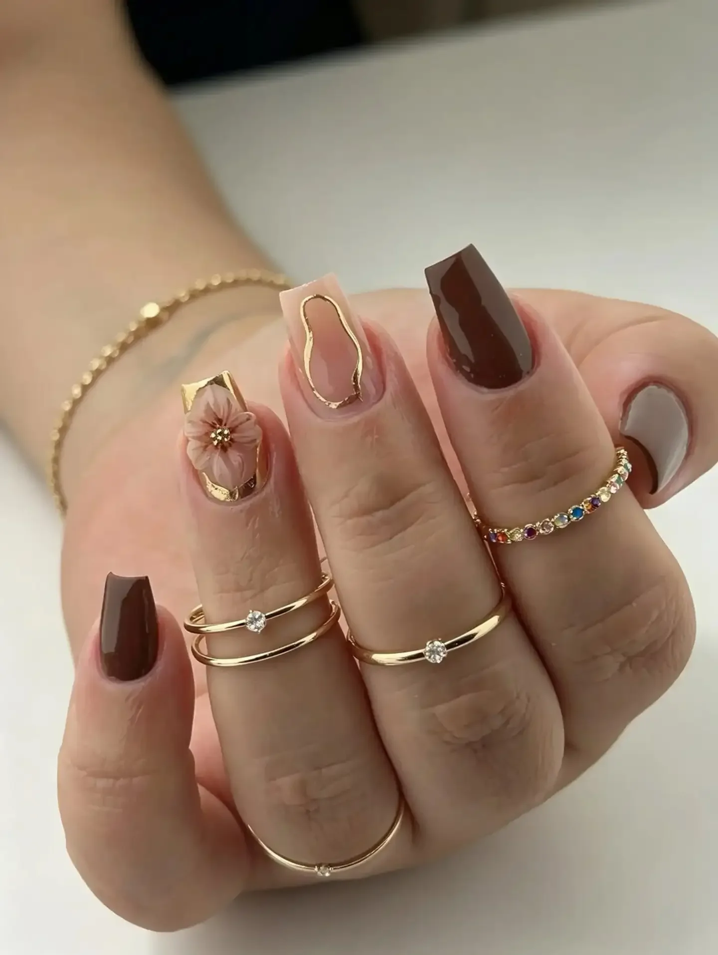 fall short coffin nails designs 2026 Chocolate And Nude Coffin Nails With Gold Outlines And Floral Details