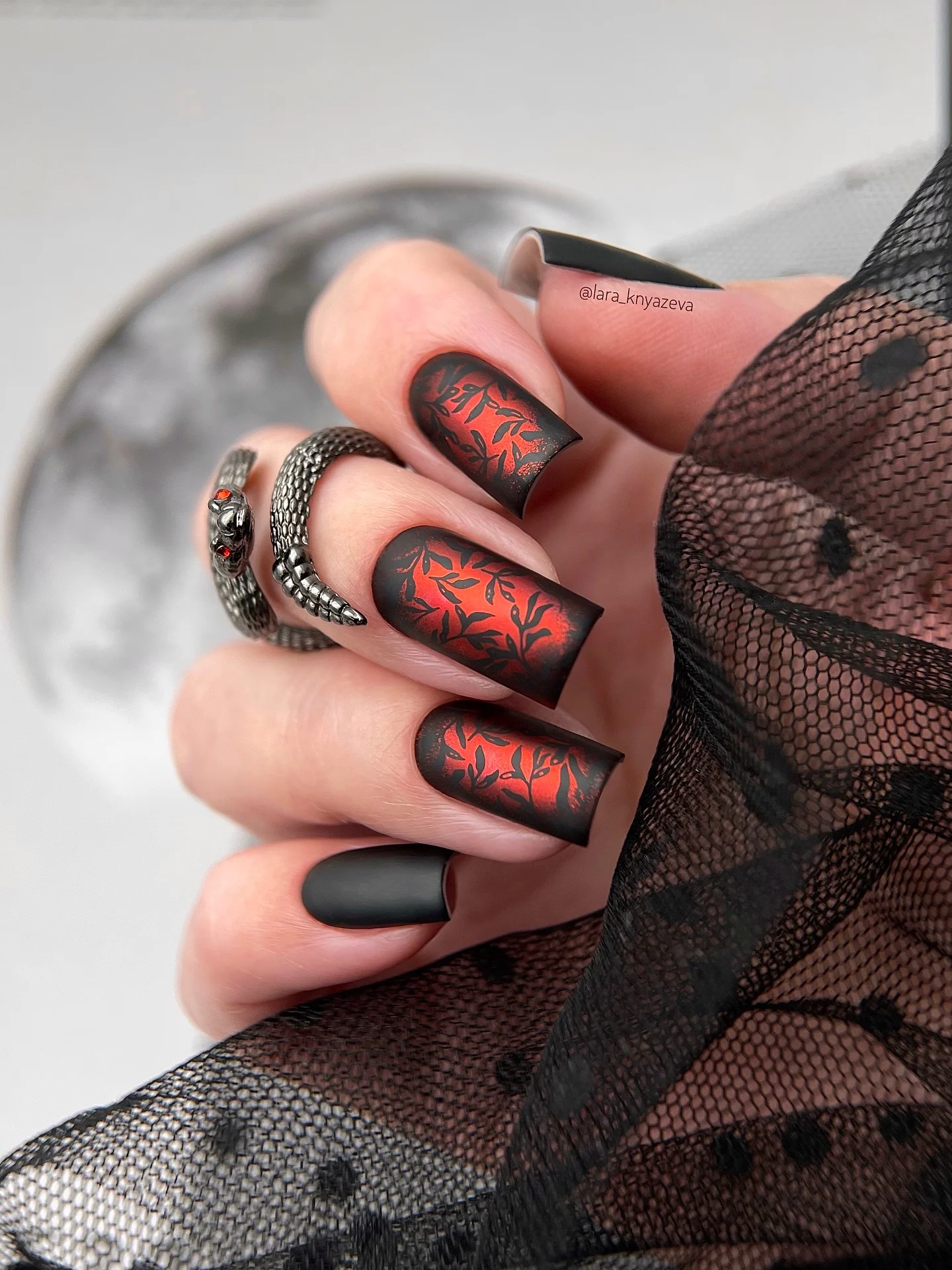 fall dark nail shadow ideas 2026 Matte Black And Fiery Red Botanical Nails