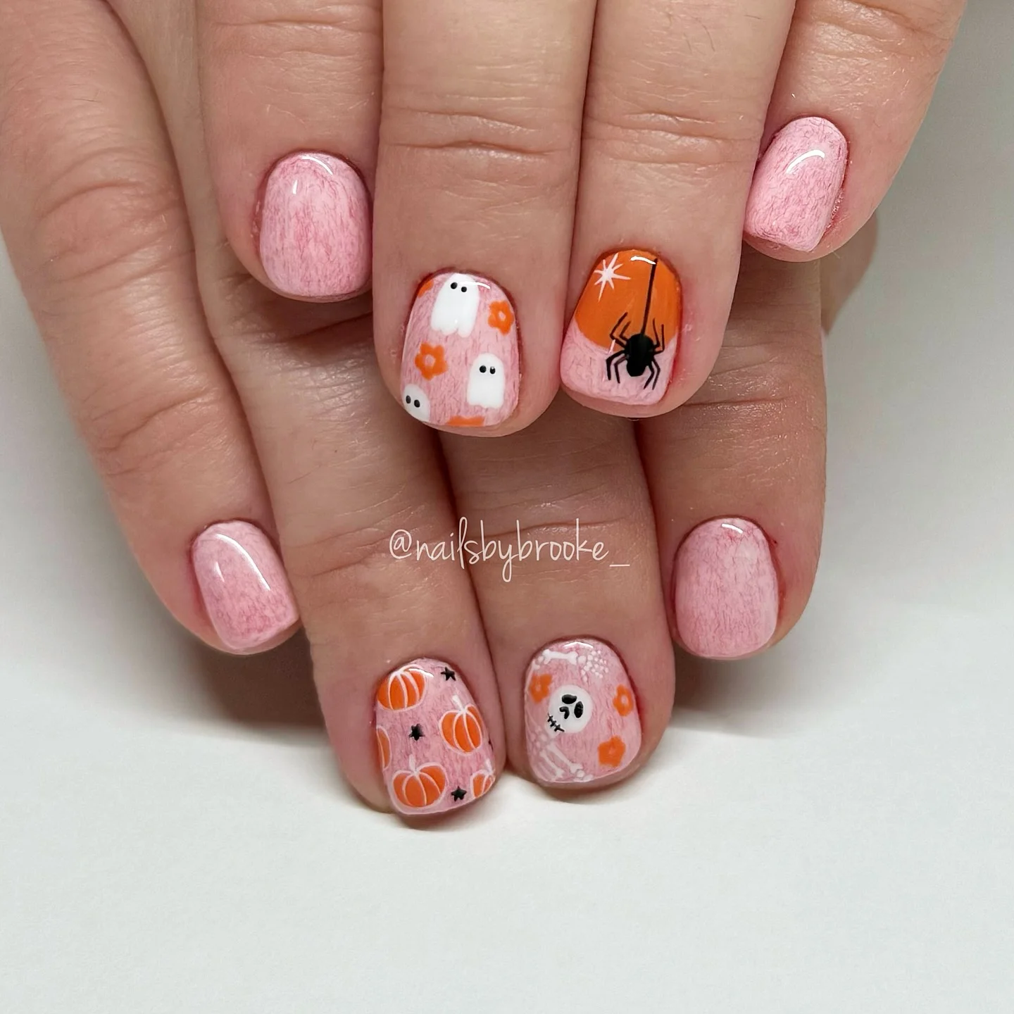 halloween nail art 2026 Soft Pink Halloween Nails With Tiny Ghosts And Spiders