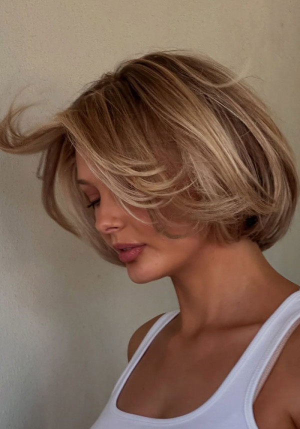 Short Warm Blonde Bob with Curtain Bangs & Voluminous Layers
