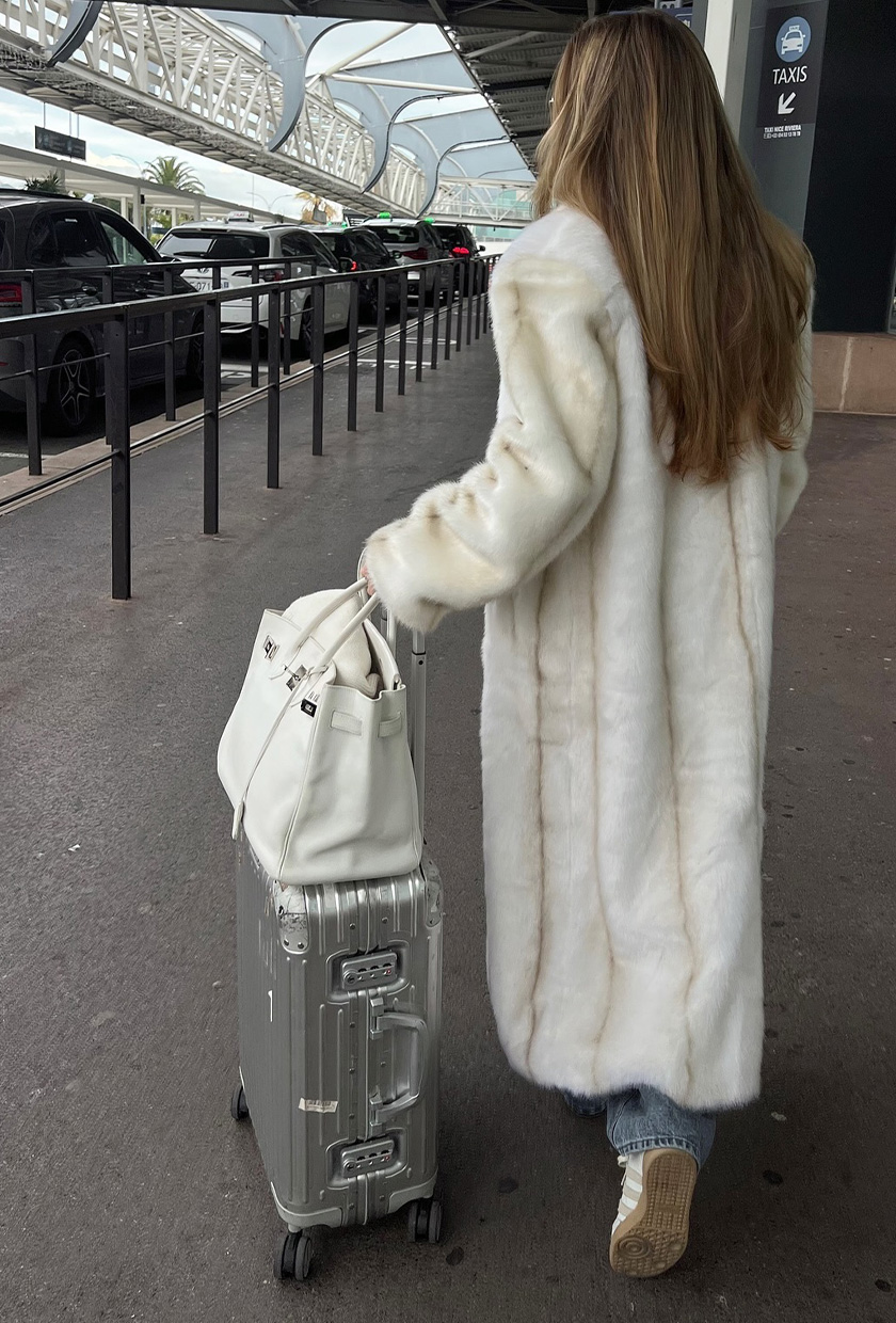 White Faux Fur Coat with Blue Jeans and Sneakers — Winter Airport Outfits