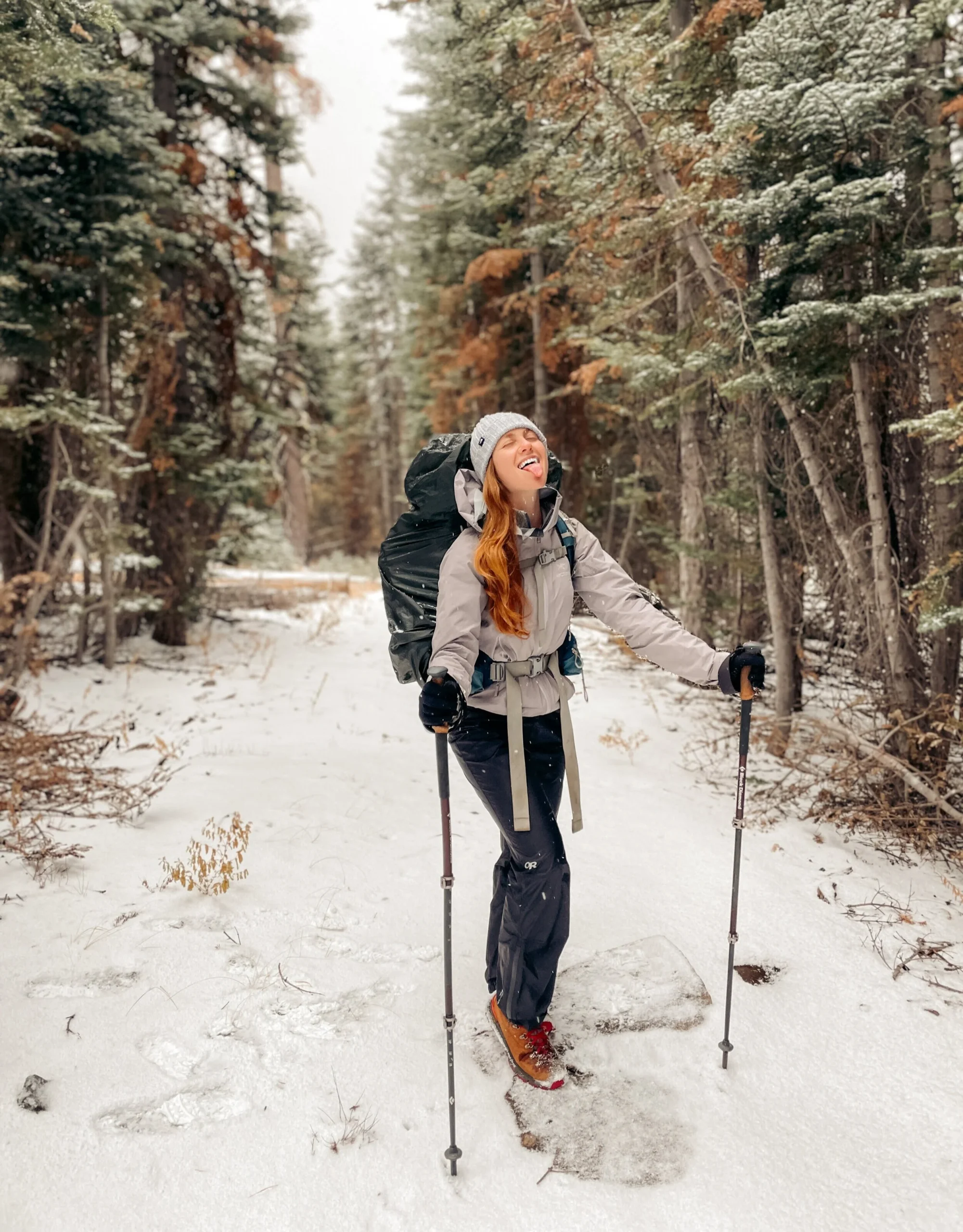 Grey Hooded Jacket with Backpack and Trekking Poles Grey Hooded Jacket with Backpack and Trekking Poles — Winter Hiking Outfits