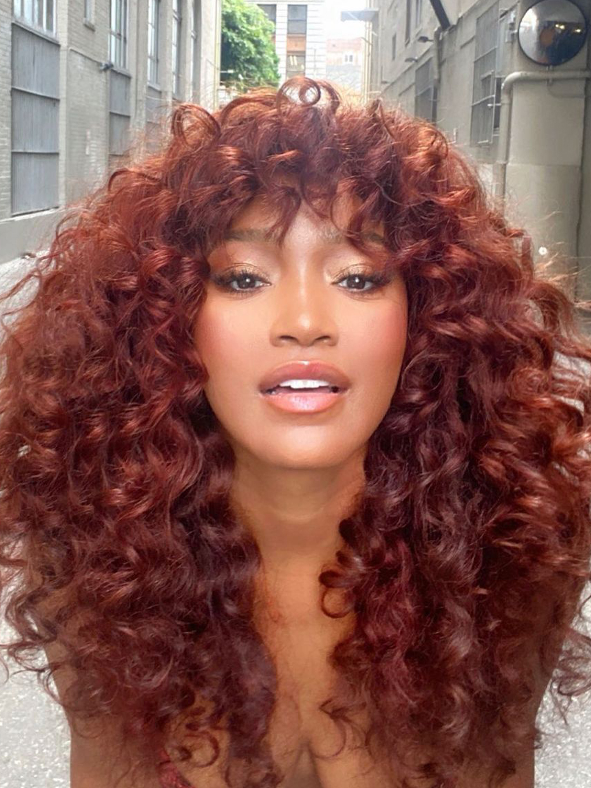 Deep Red With Full Bangs — Winter Hair Colors for Curly Hair