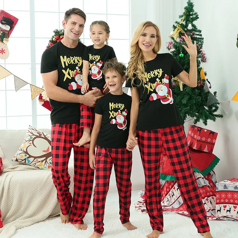 Coordinated Santa Print T-Shirts and Plaid Pants for a Festive Family Coordinated Santa Print T-Shirts and Plaid Pants for a Festive Family — Winter Family Photo Outfits