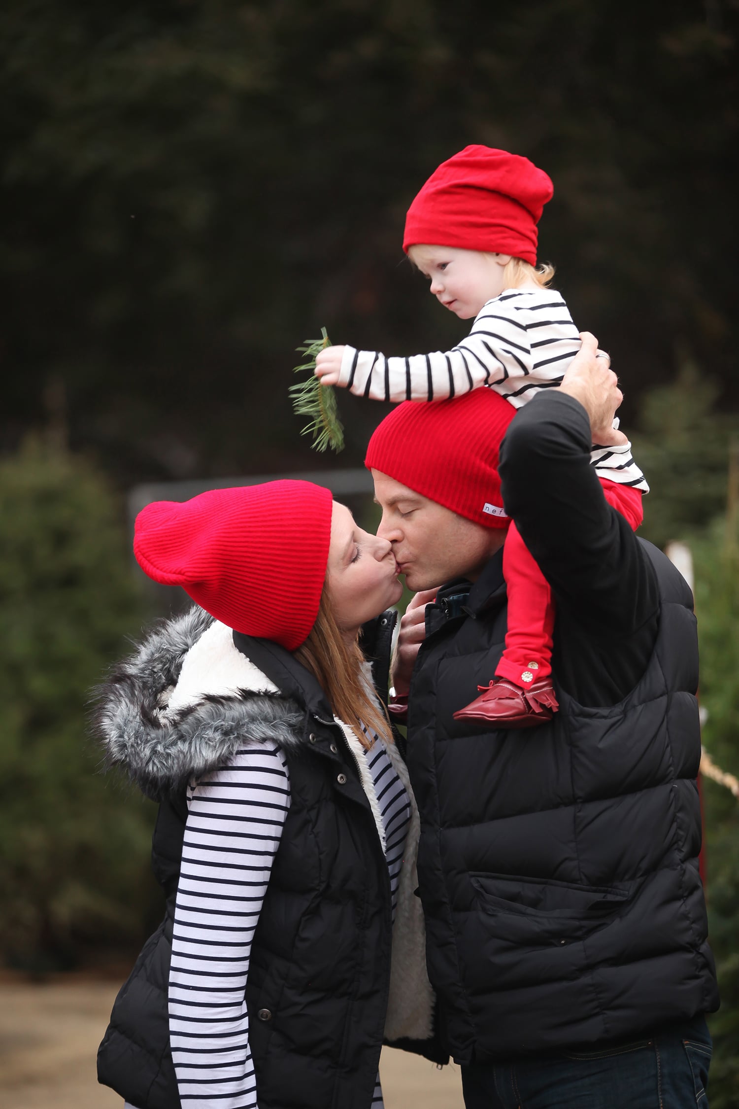Matching Red Beanies and Puffer Vest for a Chic Family Look Matching Red Beanies and Puffer Vest for a Chic Family Look — Winter Family Photo Outfits