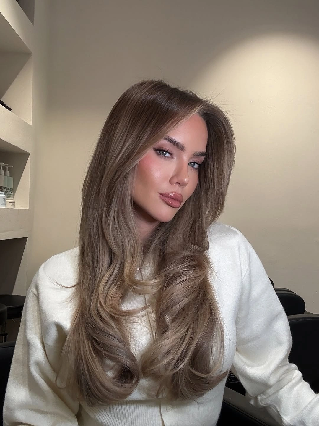 Long taupe brown hair with beige reflections and curved layered ends