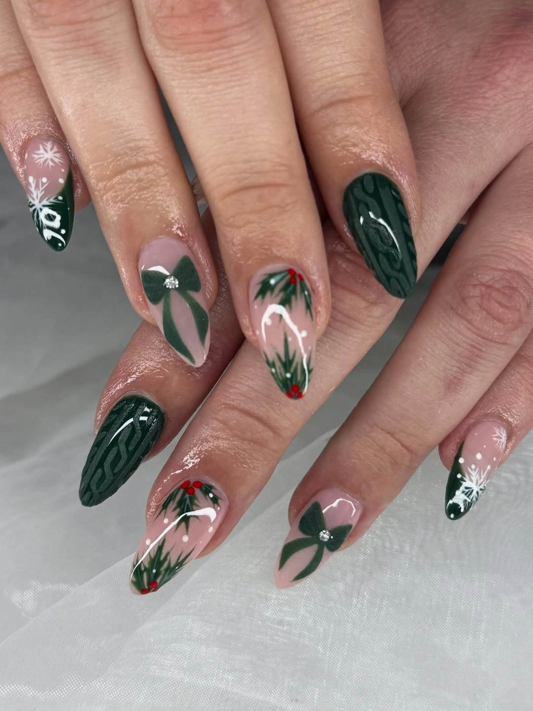 Almond nails with dark green wavy patterns pink bases and red berry accents