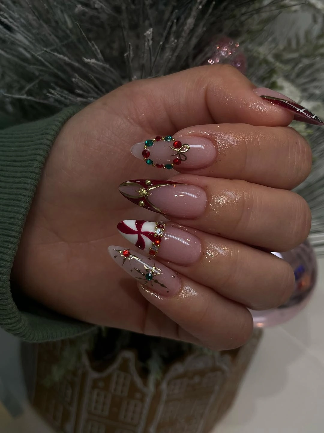 Long nude pink nails with colorful jeweled wreath and candy cane decorations