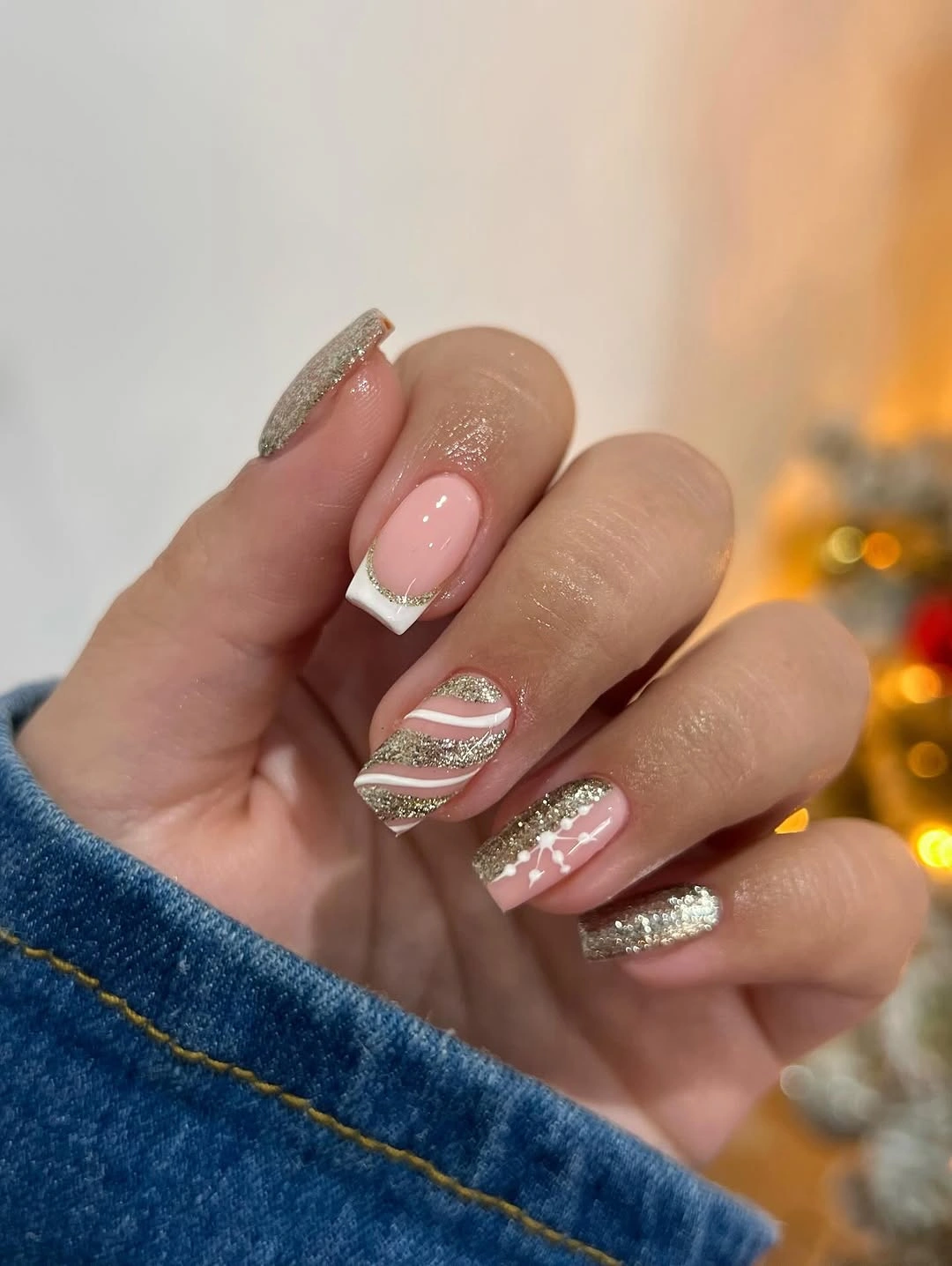Pink square nails with white French tips gold glitter stripes and snowflake