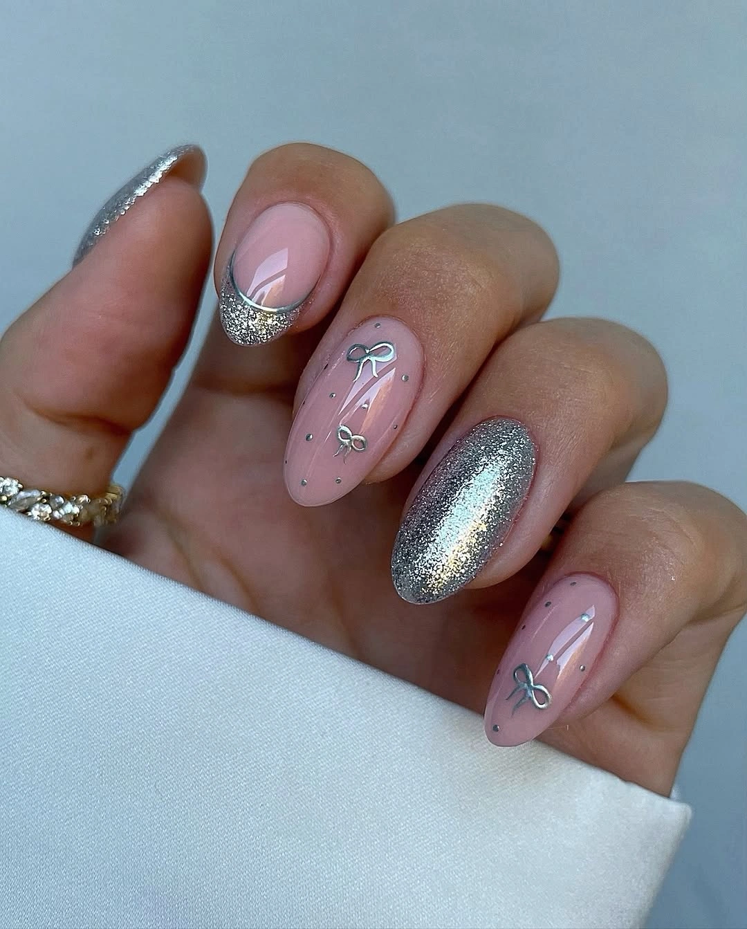 Almond pink nails with silver bows glitter tips and shimmering accent