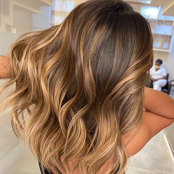 Mid-Back Wavy Blowout With Dark Brown to Honey Balayage