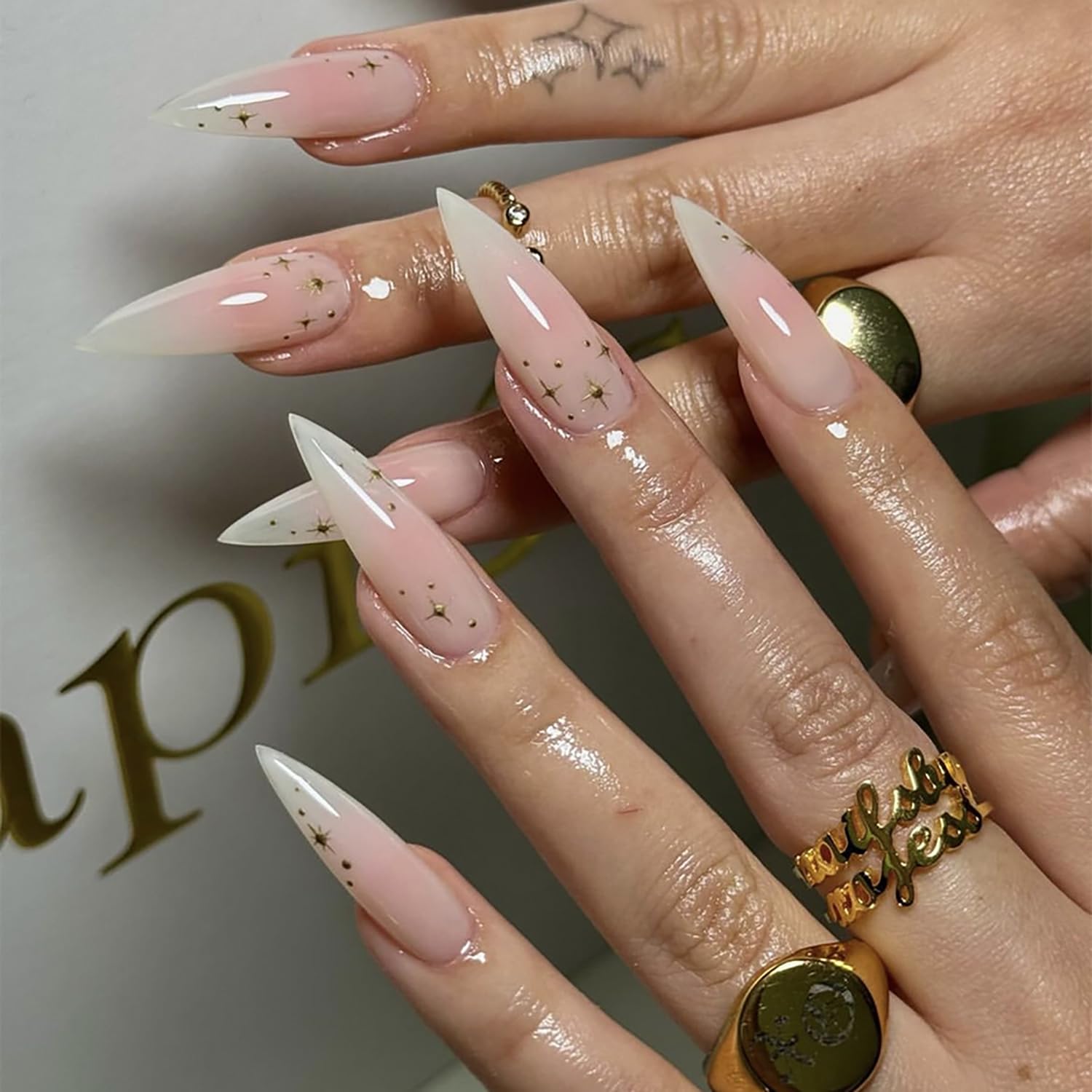 Sheer Pink To White Gradient Stilettos With Gold Stars Sheer Pink To White Gradient Stilettos With Gold Stars — Long Acrylic Nails